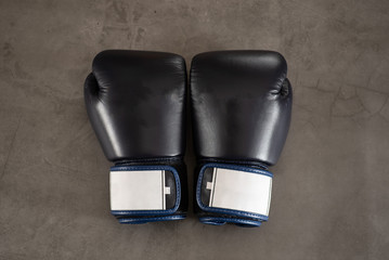 Navy Blue Boxing gloves on a industrial, rustic concrete floor background.