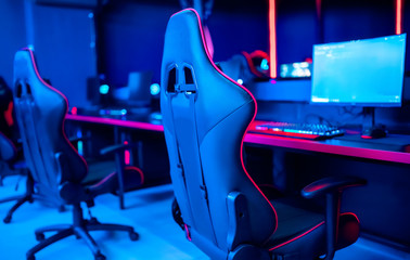 Professional cyber gamer studio room with personal computer armchair, keyboard for stream in neon color blur background. Soft focus © Parilov