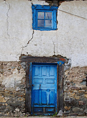 Door and intense blue window on old wall with textures