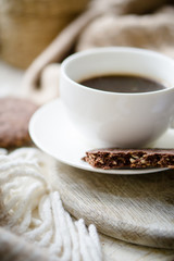 Cup of coffe with milk and chocolate cookies on warm wool blanket
