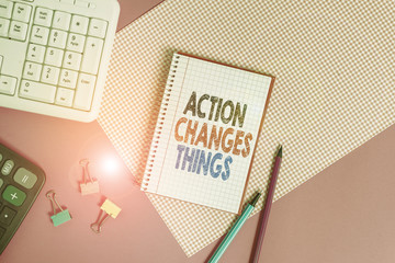 Text sign showing Action Changes Things. Business photo showcasing doing something will reflect other things Reaction Writing equipments and computer stuffs placed above colored plain table