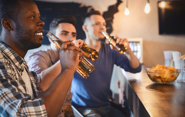 Young football fans watching game in pub