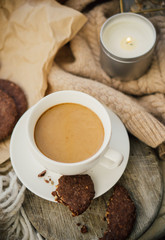Cup of coffe with milk and chocolate cookies on warm wool blanket