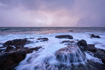 Coast of Norwegian sea on rocky coast in fjord on sunset