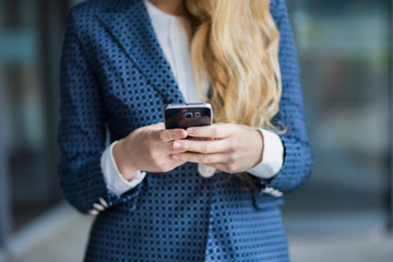 Fototapeta premium Detail of a woman using her smartphone outdoor