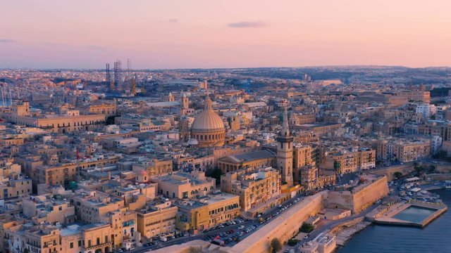 Aerial circling view of Valletta, Malta with Basilica of Our Lady of Mount Carmel at sunset