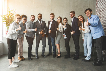 Positive interracial business people showing thumbs up