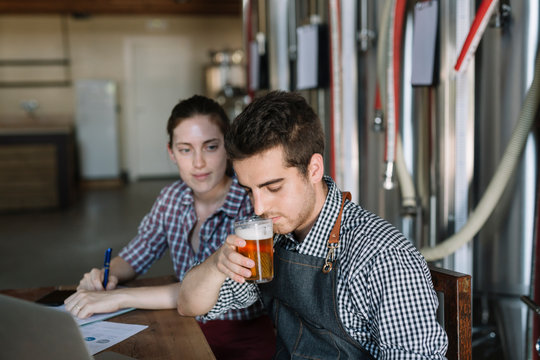 Young entrepreneurs working at a brewery testing beer