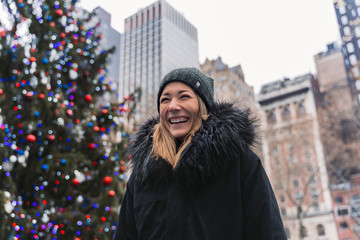 Portrait of a young woman in front of a christmas tree in the City of New York