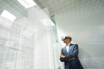 Businessman wearing VR goggles, looking at virtual architecture