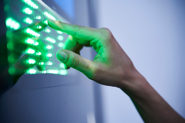 Detail of finger touching green led touchscreen