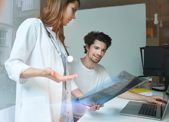 Two doctors talk x-ray image at desk