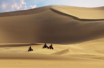 Fototapeta na wymiar Driving off-road with quad bike or ATV vehicles. Namib sand desert on the background