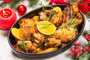 Christmas food - roasted chicken with orange on white table.