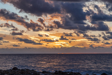 Fototapeta premium atardecer en salinas de Agaete con cielo naranja y nubes