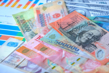 Obraz premium Business and Financial Concept. Multiple Currencies Banknote with laptop on graph and chart.