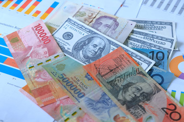 Business and Financial Concept. Multiple Currencies Banknote with laptop on graph and chart.