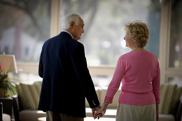 elderly couple holding hands