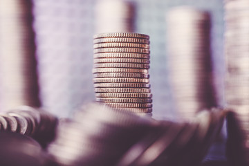 Stack of golden coins, shallow depth of field, color toning applied.