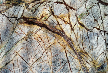 Yellow-blue marble texture, with dark streaks. close up