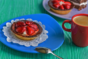 Cake with berries on a ceramic plate standing on a wooden background.