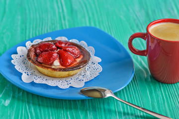 Cake with berries on a ceramic plate standing on a wooden background.