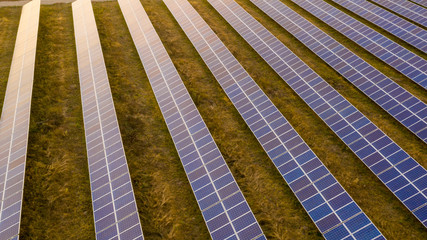 Renewable electricity, unmanned flight over a solar power plant located in the field.