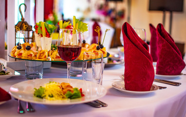 Banquet. Wedding. festive table setting. The wedding table is decorated with beautiful Burgundy napkins. Interior, beautiful food.