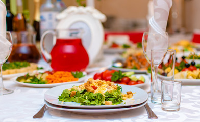 Wedding. Event. Banquet. Decorated festive table with plates and glasses, beautiful white napkins. A plate of grapes, apples and peaches. Decanters with Morse red.