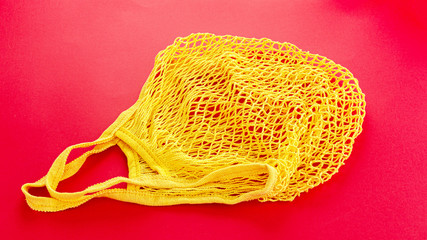 One reusable cotton net bags or mesh bags on coloured background