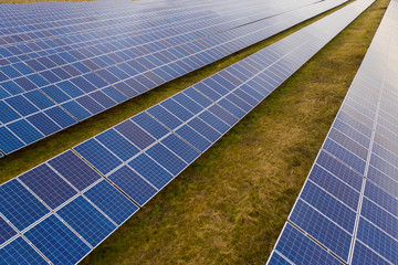 Renewable electricity, unmanned flight over a solar power plant located in the field.