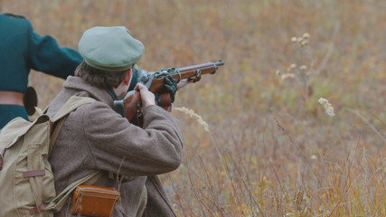 A military man is ready to shoot right on the field