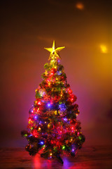 Christmas tree with festive lights, orange background