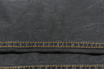 Black jeans texture with gold thread seams