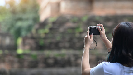 Copy space traveler woman take a photo in historic site view.