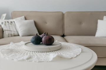 living room in light beige shades, on the table is a delicious Fig