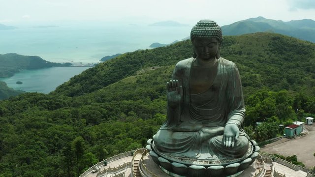 Aerial shoot of Tian Tan Buddha in Hong Kong, huge statue and amazing nature around it, hills and forests of Hong Kong countryside