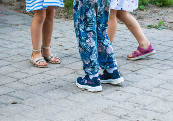 The girls who met in the summer had different girls' feet in shoes, one with blue floral pants and two with dresses.