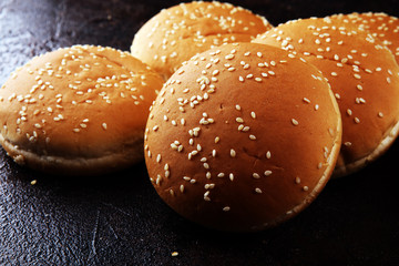 Fresh homemade burger buns with sesame on dark background