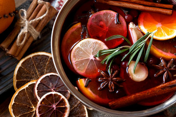 Mulled wine with citrus fruits and spices. Winter grog cooking with orange, lemon, cinnamon and anise