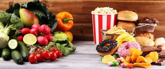 Foto op Plexiglas healthy or unhealthy food. Concept photo of healthy and unhealthy food. Fruits and vegetables vs donuts and fast food © beats_