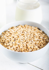 Rolled oats or oat flakes in wooden bowl