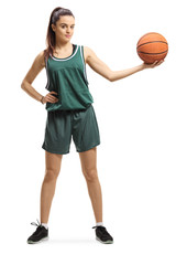 Yung female basketball player posing with a basket in one hand