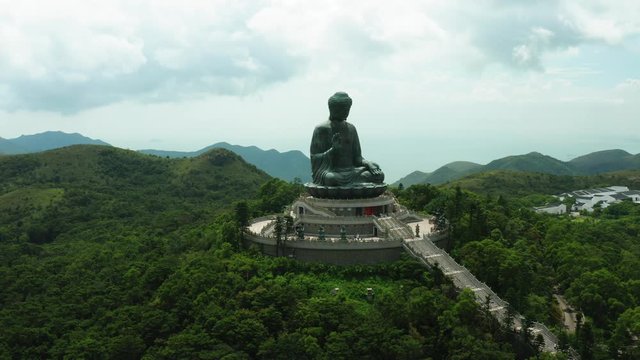 Aerial shoot of Tian Tan Buddha in Hong Kong, huge statue and amazing nature around it, hills and forests of Hong Kong countryside