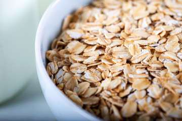 Rolled oats or oat flakes in wooden bowl