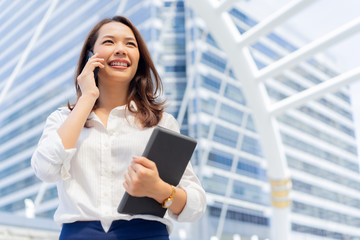 close up young entrepreneur businesswoman talking on smartphone and looking forward to outside...
