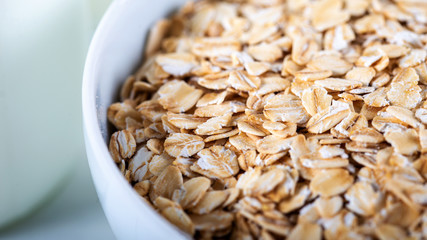 Rolled oats or oat flakes in wooden bowl
