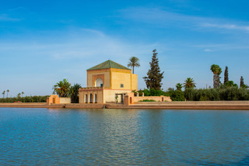 Obraz premium Menara Gardens botanical garden located to the west of Marrakech, Morocco. Pavilon and blue water of basin against atlas mountains 