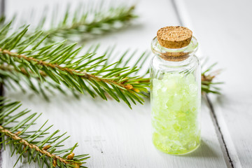 fir branches and spruce bath salt on white table background