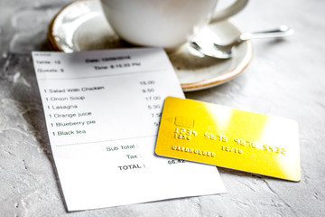 restaurant bill paying by credit card for coffee on stone table background